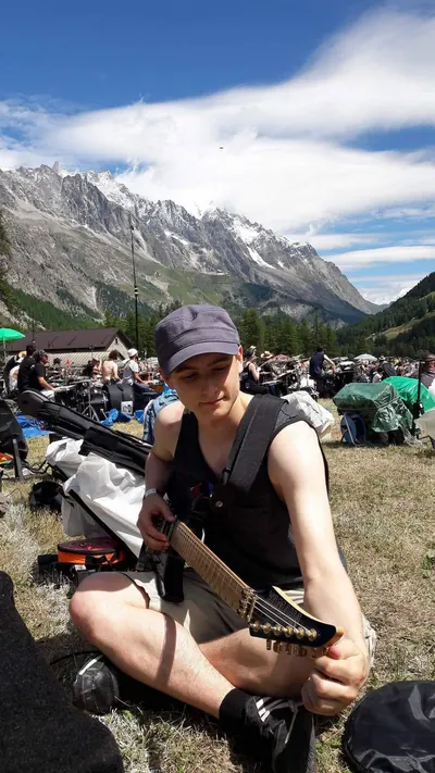 Me with a bass at Rockin'1000, a field of players under the Alps